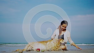 Asian woman relaxing with dog on the beach. Recreation and lifestyle on summer holiday