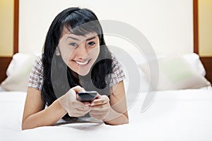 Asian woman with a remote control in a hotel room