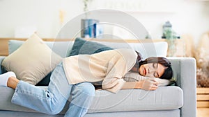 Asian woman resting at home on couch