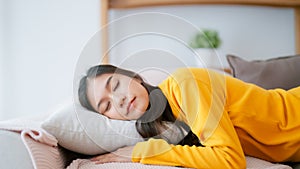 Asian woman resting at home on couch