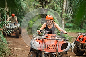 asian woman riding the atv with full of spirit through the track