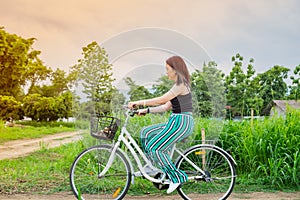 Asian woman riding a bicycle at countryside