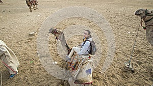 Asian woman riding camel  at Giza pyramid Egypt scary activity and exciting for tourist