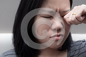 Asian woman rubbing her eye. because of  eye`s problem, dust allergy, dry eye, watery, itching or contact lenses problem