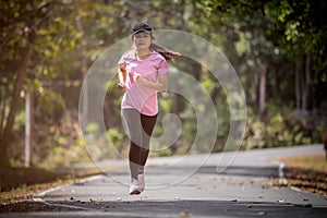 Asian woman runner running in the morning tropical forest trail. Concept nature and sport lifestyle