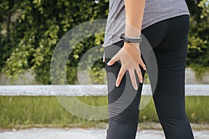 Asian woman runner suffering from pain in legs be injured,Hand touching her muscle thigh after jogging on track running
