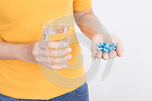 Asian woman`s hand holding capsule and glass on white background,Health and medical concept