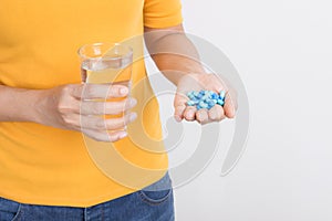 Asian woman`s hand holding capsule and glass on white background,Health and medical concept