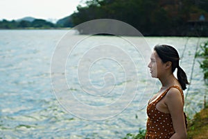 Asian Woman 40s LGBT transgender express feeling lonely alone sad under sunshine on water river