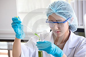 asian woman Scientist Research and Reaction woman pouring a liquid in a tube in Laboratory , science biology medicine chemistry