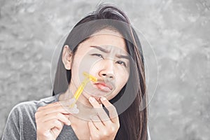Asian woman shaving mustache on face with a razor