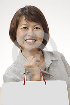 Asian woman with shopping bags and a big smile