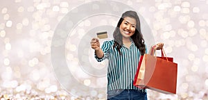 Asian woman with shopping bags and credit card