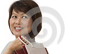 Asian woman with shopping bags looking up