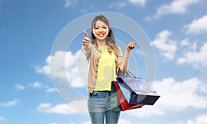 Asian woman with shopping bags showing thumbs up