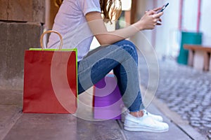 Asian woman shopping holding shopping bag and use of mobile phone at shopping center. Consumerism, sale and people online concept