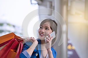 Asian woman shopping smile and holding shopping bag with cell p