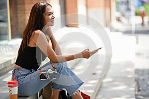 Asian woman shopping in sunny day concept, sitting on stairs outside of the mall