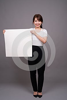 Asian woman showing empty white board with copyspace