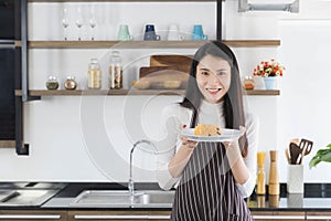 Asian woman showing fried rice in kitchen