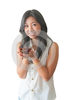 An Asian woman showing red grape