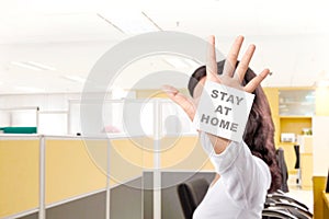 Asian woman showing stop hand gesture with a note for Stay at home