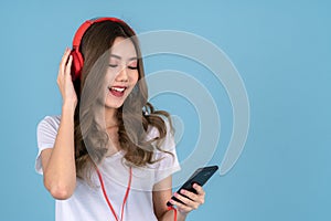 Asian woman sing a song with headphones and smartphone on her hand