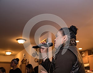 Asian woman singing karaoke at a party