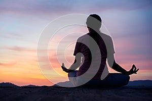 Asian  woman sit  lotus yoga position at sunset . Practicing yoga makes meditation for healthy breathing  and relaxation