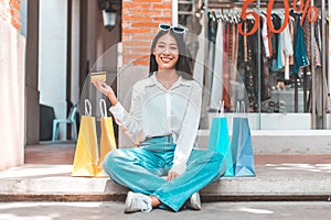 Asian woman sit rested after shopping in a colorful bag and she was happy to go shopping