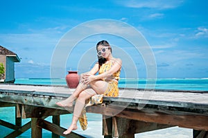 Asian woman sits on the pier. Vacation and travel concept stock photo