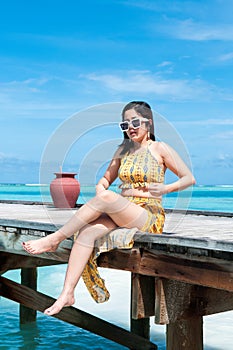 Asian woman sits on the pier. Vacation and travel concept stock photo