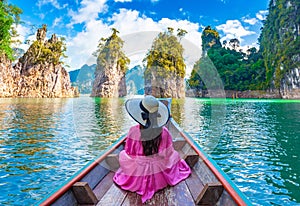 Asian woman sitting on boat in Ratchaprapha dam Khao sok national park at suratthani,Thailand