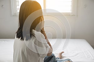 Asian woman sitting and depress have a headache and feeling sorrow in bedroom