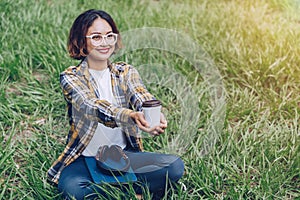 Asian woman sitting and drinking coffee in the garden