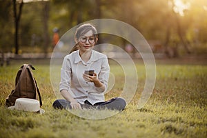 Asian woman sitting on the grass in the garden.