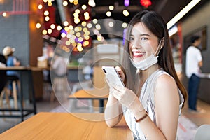 Asian woman sitting separated in restaurant eating food .keep social distance for protect infection from coronavirus covid-19,