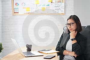 Asian woman sitting in stylish watching interesting training webinar online