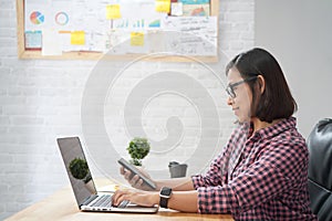 Asian woman sitting in stylish watching interesting training webinar online