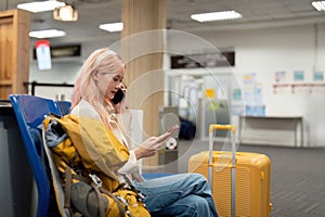 Asian woman sitting in waiting room and talking over smartphone. woman travel talking on cell phone at airport lounge