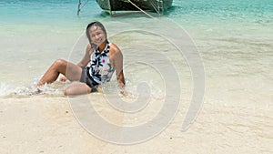 Asian woman sitting in water on tropical island