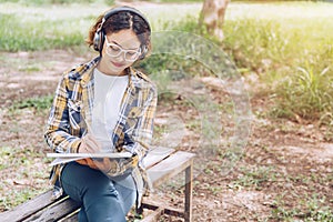 Asian woman sitting and writing in the garden