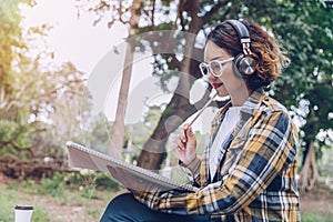 Asian woman sitting and writing in the garden