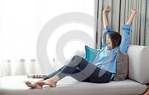 Asian woman sleep and relax on sofa bed in her living room