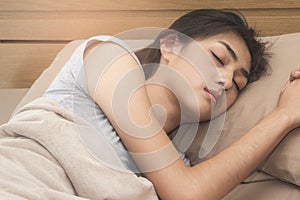 Asian woman sleep well on the bed at night.