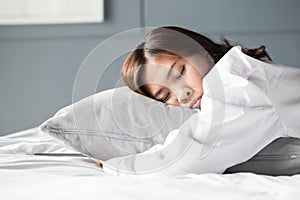 Asian woman sleeping on bed