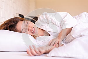 Asian woman sleeping on the bed and grinding teeth,Female tiredness and stress photo
