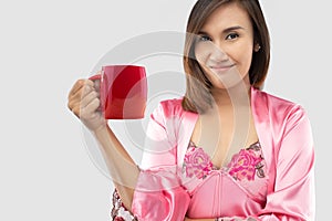 Woman holding a red cup of coffee in the morning