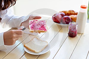 Asian woman slice jam bread in the morning and eating apple fruit,coffee healthy food breakfast
