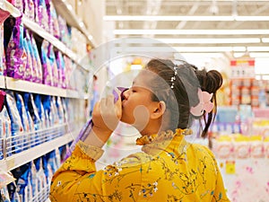 Asian woman smelling / choosing liquid softener